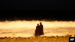 Dua perempuan Saudi menikmati pantai Laut Merah di Jeddah, Saudi Arabia di waktu malam (foto: ilustrasi). 