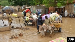 Des habitants de Niamey, capitale du Niger, évacuent leurs maisons inondées, le 19 août 2012. (AFP PHOTO / BOUREIMA HAMA)