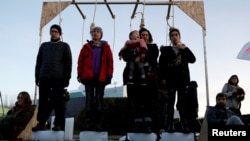 Climate change activists of Extinction Rebellion take part in a performance in front of the U.N. Climate Change Conference (COP25) in Madrid, Spain, Dec. 14, 2019.