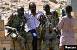 Sudanese military officers and a demonstrator pose for a photograph during celebration after Defense Minister Awad Ibn Auf stepped down as head of the country's transitional ruling military council, near the Defense Ministry in Khartoum, Sudan, April 13,