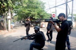 FILE - Protesters hold homemade pipe air guns during a protest against the military coup in Yangon, Myanmar, April 3, 2021.
