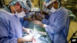 Dr. Sunil Singhal, right, directs a special camera to be able to view his patients tumor on monitors while performing surgery at the Hospital of the University of Pennsylvania in Philadelphia, Tuesday, Jan. 23, 2018.