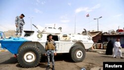 Petugas keamanan berjaga-jaga di lokasi serangan bom mobil di Baghdad (26/8). 
