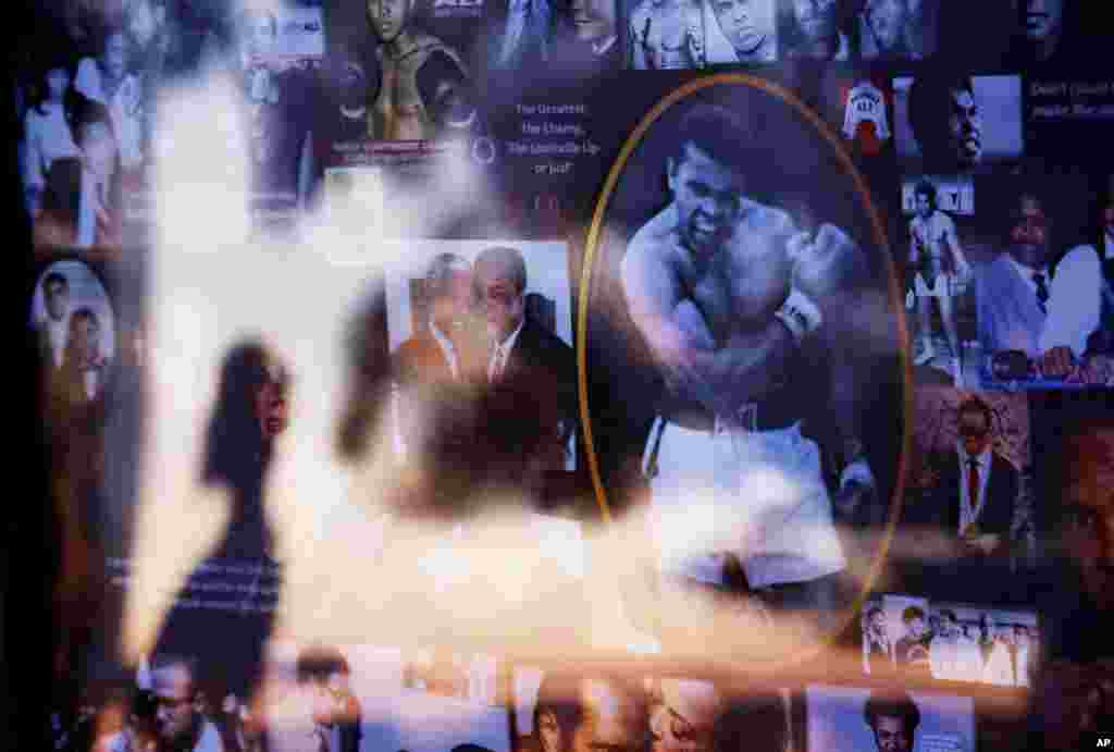 Muhammad Ali Memorial: A collage of Muhammad Ali images is displayed as a visitor is reflected in the glass while looking over a makeshift memorial to Ali at the Muhammad Ali Center Thursday, June 9, 2016, in Louisville, Kentucky.
