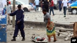 Une femme marche près d'un cadavre à Kinshasa, le 19 septembre 2016.