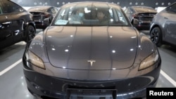 Konsumen mencoba mobil Tesla Model Y di pusat dealer Tesla di Beijing, China (foto: dok). 