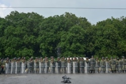 Members of the Mexican National Guard stand with their shields in case of a confrontation during the migrant caravan near Tuzantan, Chiapas state, Mexico, Oct. 12, 2019. Hundreds of migrants were arrested as they made their way to Mexico City.