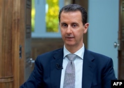 A handout picture released by the Syrian presidency's press office shows Syrian President Bashar al-Assad during an interview with AFP in the capital Damascus, on April 12, 2017.