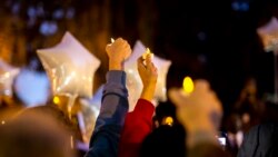 Puluhan orang menyalakan lilin elektrik dalam acara doa bersama di luar gedung Pengadilan Glynn County di Georgia, AS, saat persidangan kasus pembunuhan Ahmaud Arbery berlangsung pada 22 November 2021. (Foto: AP)