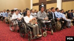 កញ្ញា​ ជា បុប្ផា​ ​អ្នក​សម្រប​សម្រប​កម្មវិធី​ប្រចាំ​មជ្ឈមណ្ឌល​ជីវិត​រស់នៅ​ដោយ​ឯករាជ្យ​នៃ​ជនពិការ​ភ្នំពេញ (កណ្តាលខាងមុខ) ​និង​អ្នកចូលរួម​ដទៃ​ទៀត​នៅក្នុងកម្មវិធីសម្ពោធ​ដាក់​ដំណើរការ​កម្មវិធី​សហប្រតិបត្តិការ​អូស្ត្រាលី-កម្ពុជា ដើម្បី​ការ​ផ្តល់​សេវា​ប្រកប​ដោយ​និរន្តរភាព និង​សមធម៌ ឬហៅថា (ACCESS) នៅ​រាជធានី​ភ្នំពេញ ថ្ងៃទី២១ ខែមីនា ឆ្នាំ២០១៩។ (ណឹម​ សុភ័ក្រ្តបញ្ញា/VOA)⁠