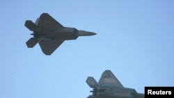 FILE - Two US F-22 fighter jets are seen in flight.