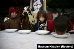 Orphelins buvant du lait offert par une association caritative à Harasta, dans la banlieue de Damas en Syrie, le 30 janvier, 2016. (Reuters / Bassam Khabieh)