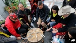 Native Americans and First Nations people join in on a drum circle during an Indigenous Peoples Day blessing and rally before a march Monday, Oct. 8, 2018, in Seattle. (AP Photo/Elaine Thompson)