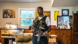 Law, Lawrence Barnes, 44 ans, entraîneur de basket-ball de Chicago et membre des Minnesota Freedom Fighters (MNFF), avec son fusil le 26 juillet 2020 à Minneapolis, Minnesota.