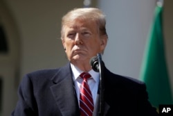 President Donald Trump listens during a news conference with Brazilian President Jair Bolsonaro in the Rose Garden of the White House, March 19, 2019, in Washington.