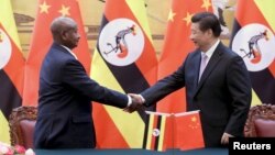 លោក​ប្រធានាធិបតី​អ៊ូហ្គាន់ដា Yoweri Kaguta Museveni (រូប​ឆ្វេង) ចាប់​ដៃ​ជាមួយ​នឹង​លោក​ប្រធានាធិបតី​ចិន Xi Jinping ក្នុង​ពិធី​ចុះ​ហត្ថលេខា​មួយ​នៅ​វិមាន Great Hall of the People ក្នុង​ក្រុង​ប៉េកាំង កាលពី​ថ្ងៃទី៣១ ខែមីនា ឆ្នាំ២០១៥។