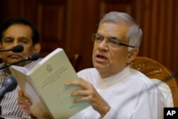 Sri Lanka's sacked prime minister Ranil Wickremesinghe holds a copy of the constitution of Sri Lanka as he attends a media briefing at his official residence in Colombo, Sri Lanka, Oct. 29, 2018.