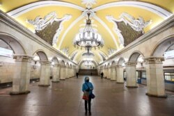 RUSSIA -- A person wearing protective mask stands in an almost deserted Komsomolskaya subway station in Moscow, April 3, 2020