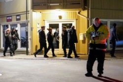 Police officers investigate at the scene where an arrow was shot into a wall after several people were killed and others were injured by a man using a bow and arrows to carry out attacks, in Kongsberg, Norway, October 13, 2021.