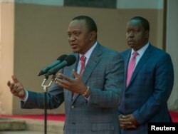 Kenya's President Uhuru Kenyatta, flanked by Interior Cabinet Secretary Fred Matiangi, addresses the media outside his office in Nairobi Kenya, Aug. 14, 2017.