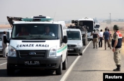 A funeral transport vehicle (front) carrying the bodies of drowned Syrian migrants, including three-year old boy Aylan Kurdi, drives to the Turkish-Syrian border in Suruc, bordering with the northern Syrian town of Kobani, Turkey, Sept. 4, 2015.