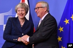 European Commission President Jean-Claude Juncker, right, greets British Prime Minister Theresa May at EU headquarters in Brussels, Nov. 24, 2018.