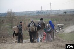 On the outskirts of the battlefields families continue to walk to Iraqi-controlled areas, carrying only a few belongings and white flags to signal they are not militants, in Mosul, Iraq, Feb. 28, 2017. (H. Murdock/VOA)