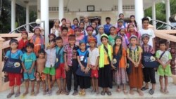 Young Cham muslim children stand in front of an informal classroom for Cham language and script learning. (Courtesy photo of Leb Ke)