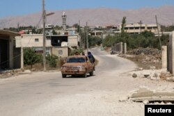 Rebel fighters ride a vehicle in Jubata al-Khashab, in Quneitra countryside, Syria Sept. 11, 2016.