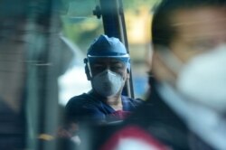 Warga mengenakan masker saat naik angkutan umum setelah pemerintah melonggarkan langkah-langkah pembatasan yang ketat selama hampir enam bulan untuk melawan penyebaran virus Covid-19, di San Salvador, 24 Agustus 2020.