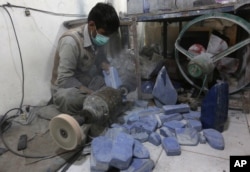 FILE - An Afghan man works at a lapis lazuli factory in the city of Kabul, Afghanistan.