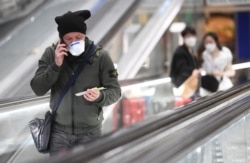 People wearing face masks are seen at the central railway station, after a coronavirus outbreak, in Milan, Italy February 24, 2020. REUTERS/Flavio Lo Scalzo