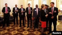 Members of the United States delegation wait outside a room where a meeting between U.S. Secretary of State John Kerry and Iranian Foreign Minister Javad Zarif, is being held at the Palais Coburg hotel in Vienna, Austria, June 28, 2015.