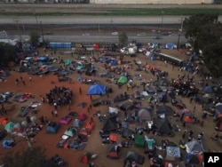 Central American migrants gather at a temporary shelter, near barriers that separate Mexico and the United States, in Tijuana, Mexico, Nov. 21, 2018.