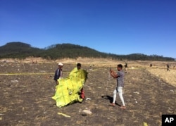 A civilian takes a photograph of the wreckage at the scene of the Ethiopian Airlines Flight 302 plane crash, March 10, 2019.