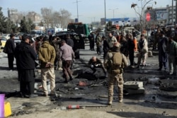 Para petugas keamanan memeriksa lokasi serangan bom maut di Kabul, Afghanistan, Rabu, 10 Februari 2021. (AP Photo / Rahmat Gul)