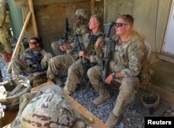 FILE - U.S. military advisers from the 1st Security Force Assistance Brigade sit at an Afghan National Army base in Maidan Wardak province, Afghanistan, Aug. 6, 2018.