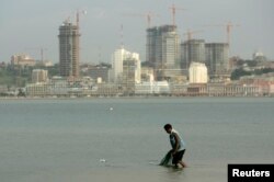 FILE - An Angolan fisherman prepares to cast his nets in the bay of Luanda, Jan. 27, 2010.