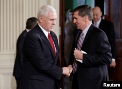 FILE - Vice President Mike Pence greets National Security Advisor Michael Flynn at the White House in Washington, Feb. 10, 2017.