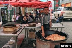 A man cooks a traditional Uyghur rice dish on the Chinese side of the China-Kazakhstan Horgos International Border Cooperation Center (ICBC), in Horgos, China, May 19, 2017.