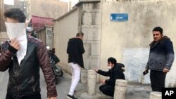 In this photo taken by an individual not employed by the Associated Press and obtained by the AP outside of Iran, people are affected by tear gas fired by anti-riot police to disperse demonstrators in a protest over the country's weak economy, in Tehran, Iran, Dec. 30, 2017.