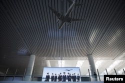 FILE - A man stands by an advertisement for North Korean airliner Air Koryo inside Pyongyang's airport, Oct. 12, 2015.