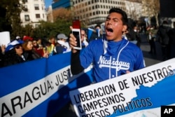 A demonstrator shouts slogans behind a banner reading in Spanish: "Release of our farmers Political prisoners" and "Nicaragua: Justice" during a protest against the Nicaraguan government in Madrid, Spain, Jan. 12, 2019.