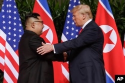 U. S. President Donald Trump shakes hands with North Korea leader Kim Jong Un at the Capella resort on Sentosa Island, June 12, 2018 in Singapore.