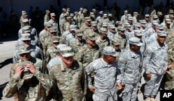 Arizona National Guard soldiers line up as they get ready for a visit from Arizona Gov. Doug Ducey prior their deployment to the Mexico border at the Papago Park Military Reservation, April 9, 2018, in Phoenix.