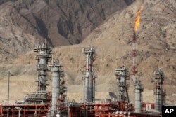 FILE - A gas flare burns in a gas refinery in South Pars gas field, on the northern coast of the Persian Gulf, in Asalouyeh, Iran, Jan. 22, 2014.