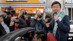 Hong Kong pro-democracy by-election candidate Au Nok-hin, right, speaks during an election campaign in Hong Kong, March 11, 2018. Polls opened Sunday in the vote pitting pro-Beijing loyalists against opposition candidates competing for four seats in the council.