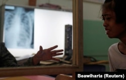 Seorang dokter (kiri) menghibur pasien tuberkulosisnya di poliklinik Persatuan Melawan Tuberkulosis di Jakarta, 4 April 2011. (Foto: REUTERS/Beawiharta)