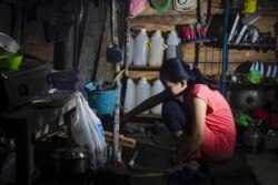Seorang gadis yang menikah di bawah umur pada Maret 2020, sedang memasak di dapurnya di Botteng Utara di Mamuju, Sulawesi Barat. (Foto: AFP/Yusuf Wahil)