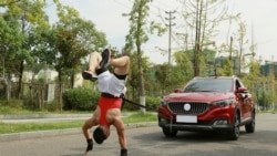Zhang Shuang, 29, attempts to set a new Guinness World Record for "Fastest time to pull a car 50 metres walking on hands" in Nan Chong City, Sichuan Province, China September 25, 2021. Courtesy of Guinness World Records 2021/Chen Maochao/Handout via REUT